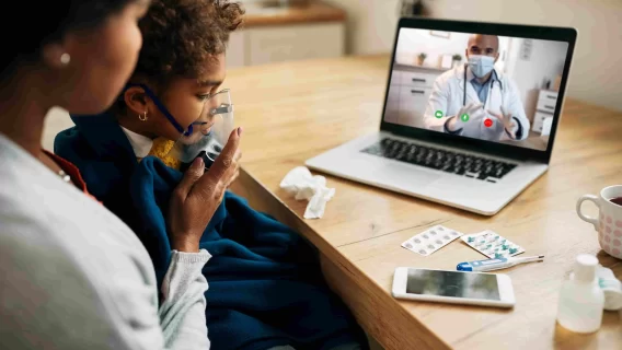 black-pediatrician-talking-via-video-call-mother-who-is-giving-her-daughter-inhaling-therapy-home